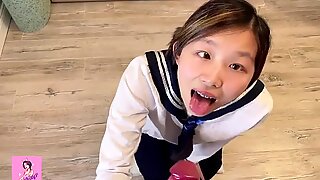 Asiatischer Teenager in japanischer Schulmädchenuniform wird von hinten durchbohrt, während er Hentai beobachtet